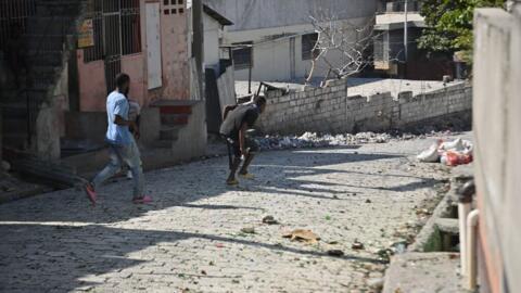 Un homme armé d'une machette court dans une rue de Solino, un quartier de Port-au-Prince, en Haïti, le 18 janvier 2024.