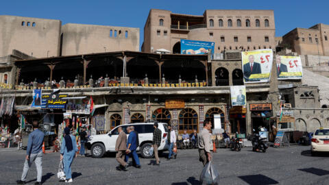 Les gens marchent dans la rue un jour après les élections parlementaires dans la région du Kurdistan irakien, à Erbil, en Irak, le 21 octobre 2024.