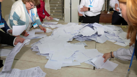 Members of an electoral commission count votes after polling stations closed in the course of Moldova's presidential election and a referendum on joining the European Union, in Chisinau, Moldova Octob