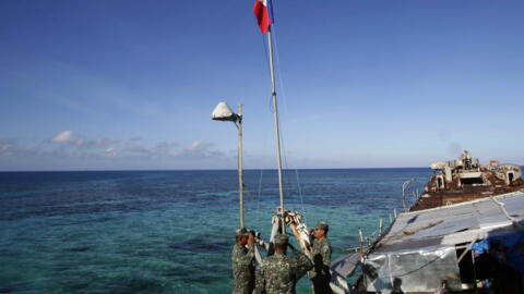 Philippine Marines raise the national flag on the first day of their deployment at the disputed Second Thomas Shoal, locally known as Ayungin Shoal, off the South China Sea, March 30, 2014.