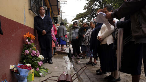 Mexicanos depositam flores no local onde o padre Marcelo Pérez foi assassinado por dois homens que fugiram de motocicleta.