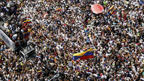 La chef de l'opposition Maria Corina Machado, en bas à droite, agite un drapeau national vénézuélien lors d'un rassemblement pour protester contre les résultats officiels qui ont déclaré le président Nicolas Maduro vainqueur de l'élection présidentielle de juillet, à Caracas, Venezuela, le samedi 17 août 2024.