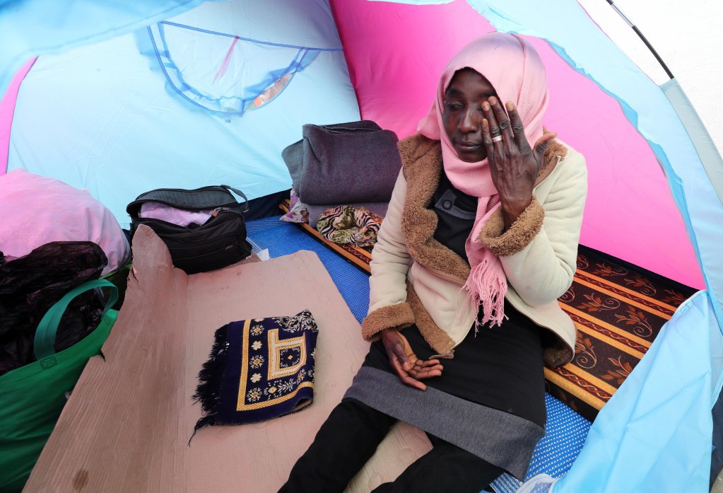 A Sudanese migrant woman sits in camp outside the headquarters of the International Organization for Migration (IOM) in Tunis, Tunisia, on March 22, 2023 | Photo: EPA/Mohamed Messara