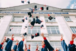 University students throwing graduation caps into the sky in celebration