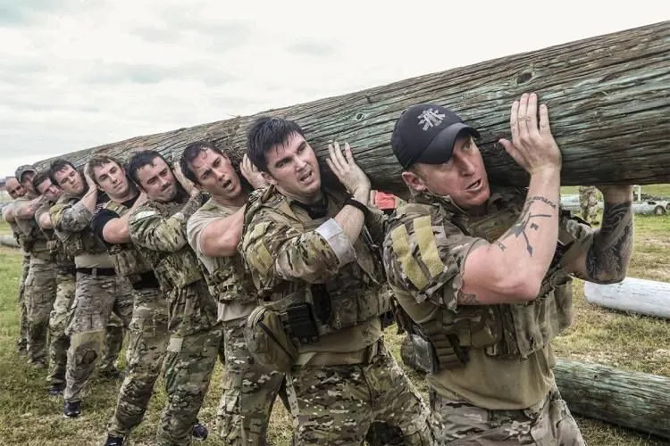 Candidates in Special Forces Training holding up a log