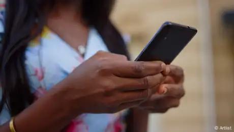 A woman holds a smartphone in her hand