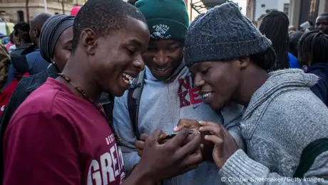 A group of boys look at something on their phone