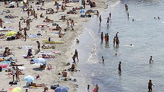 People sunbath in the Mediterranean sea at the Prophete beach, in Marseille