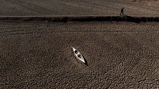 Мужчина проходит мимо брошенного каноэ на водохранилище Сау.