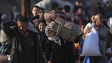 Filistinli bir kadın Gazze Şeridi'nin kuzeyinde eşyalarını evine taşıyor, 28.01.2025