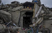 Mohammad Naser sits by a fire as he takes cover from the rain under the destruction of his house caused by the Israeli air and ground offensive in Jabaliya, Gaza Strip.