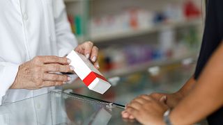 Um farmacêutico dá o tratamento a um doente.