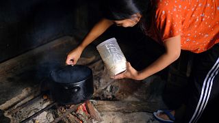 Uma mulher cozinha numa fogueira em Kohima, Índia, na quinta-feira, 10 de outubro de 2024.