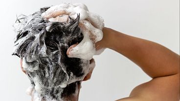 Uma pessoa lava o cabelo.