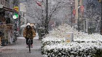 Uma pessoa anda de bicicleta enquanto a neve cai em Tóquio, a 6 de janeiro de 2022