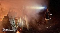 Bombeiros apagam incêndio em casas particulares após um ataque aéreo russo com bomba guiada em Kherson, 15 de março de 2025