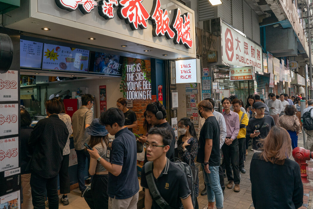 在香港太古城附近，人们在中午排队购买两菜一汤的午餐。如今，最受欢迎的是那些提供既便宜又丰富菜肴的餐馆。