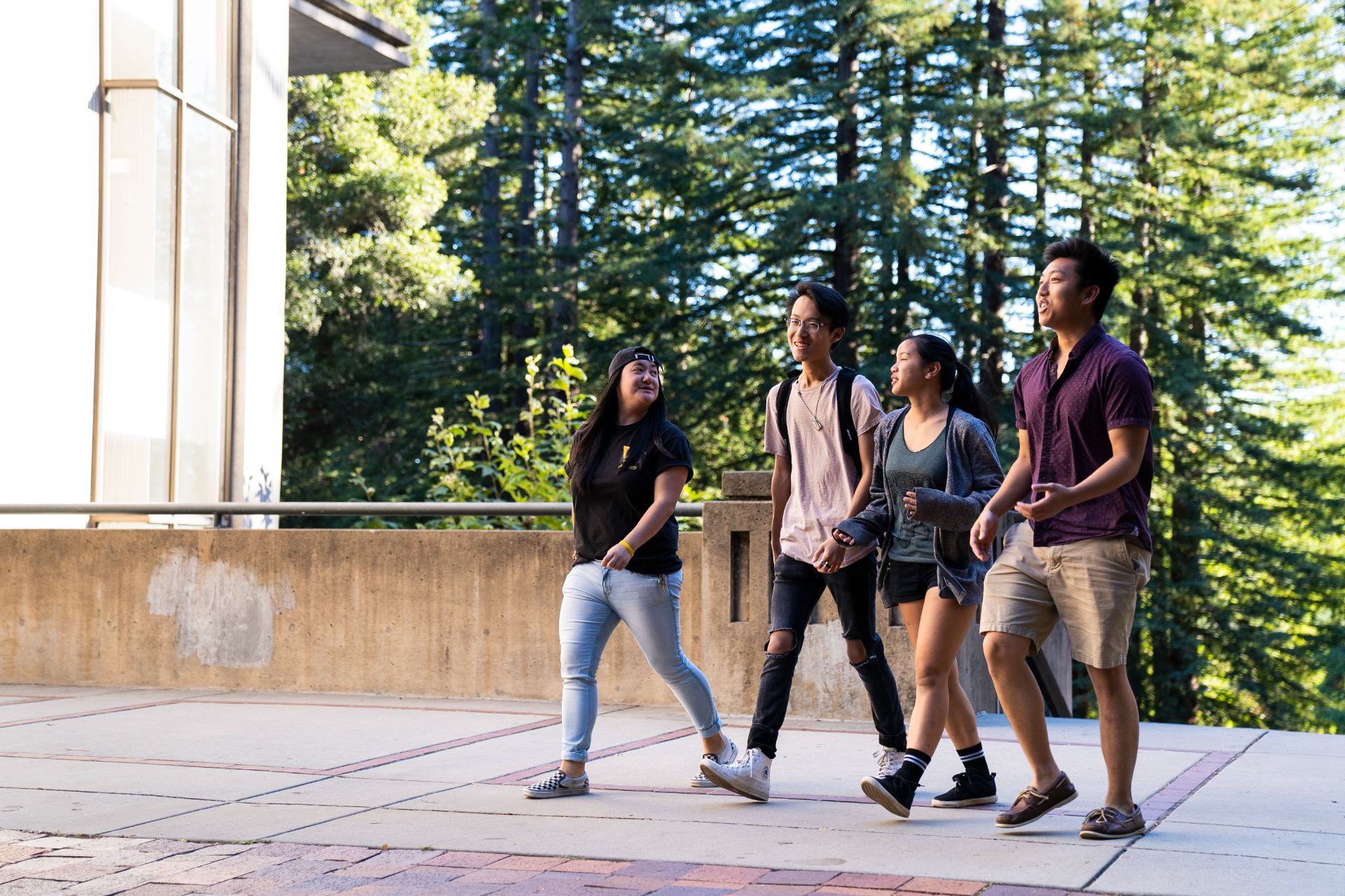 Four students walking and talking outside on UCSC campus