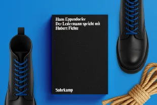 Zu sehen ist: das Buch Der Ledermann spricht mit Hubert Fichte, umgeben von Springerstiefeln und einem Seil.