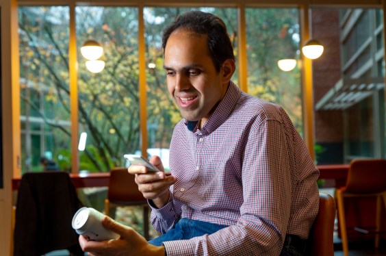 Microsoft Seeing AI Engineer Saqib Shaikh photographed at Studio C on the Microsoft campus using Seeing AI app on a mobile phone to read a labels on a can