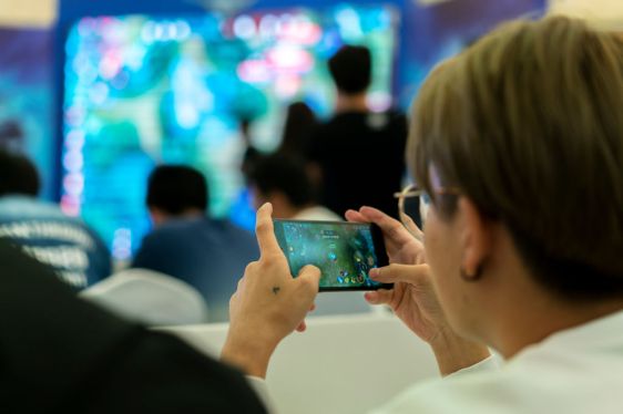 TIANJIN, CHINA - 2017/10/01: Young players compete in a battle match of the mobile game Arena of Valor, held in a shopping mall. Arena of Valor: 5v5 Arena Game, China's most popular mobile game developed by Tencent Inc, which is the world's largest mobile games developer. In the first half of 2017, the sales of China's online game market reached 99.78 billion yuan, of which the revenue from mobile games industry arrived at 56.2 billion yuan, ranking first in the world.