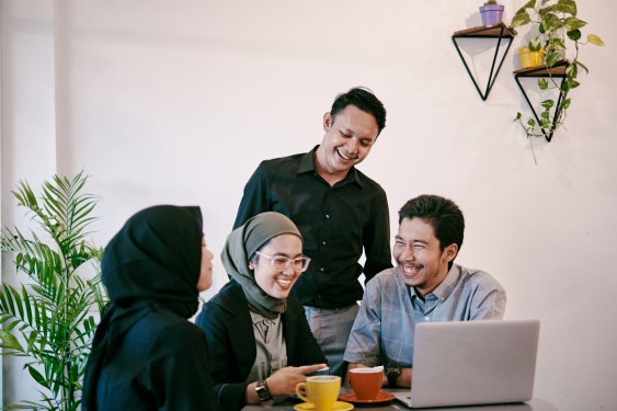 Group of employees gathered around a laptop in an Indonesian office, used in a post about Mindtera