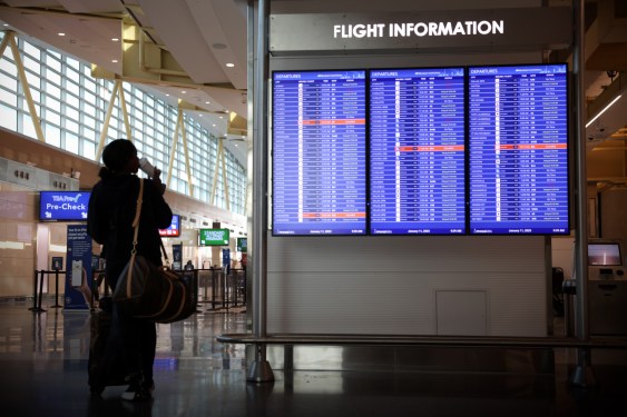 A traveler looks at a flight information board at Ronald Reagan Washington National Airport