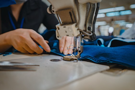 Close up of the hands of a sewist working at an industrial sewing machine