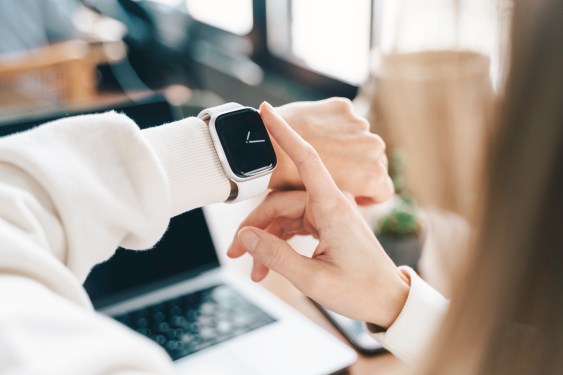 Modern woman using smart watch for daily tasks, interacting with the touchscreen user interface. Tracking health habits, messaging, checking on time with simple application software.