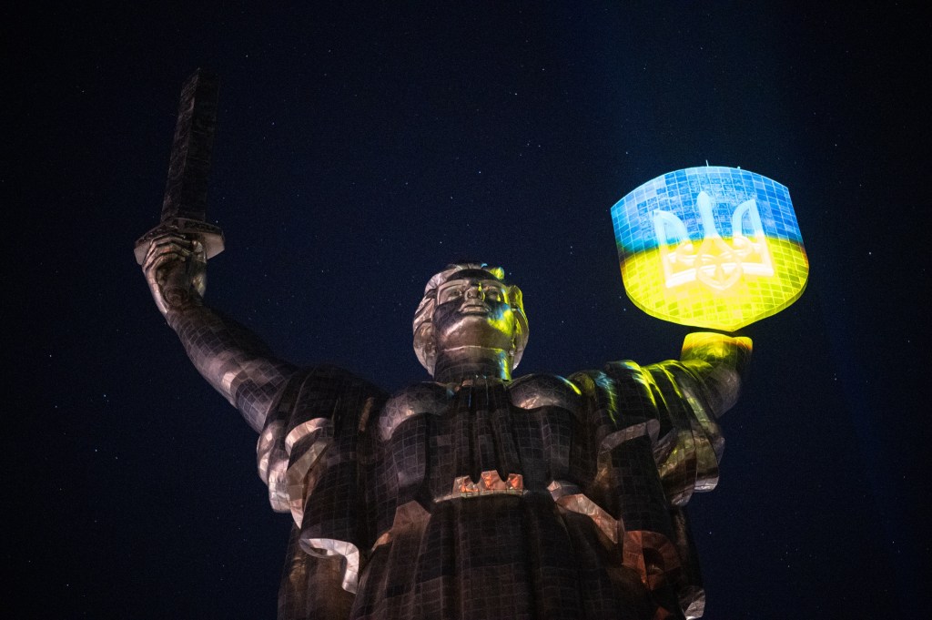 Shield of the statue of the Motherland is illuminated in the colors of the Ukrainian flag during the "Light the Fire" event where 1000 candles are lit on the 1000th day of the full-scale war with Russia at the National Museum of the History of Ukraine in the Second World War in Pechersk district of Kyiv, Ukraine on November 19, 2024.