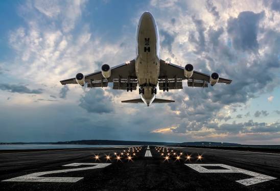 Passenger airplane taking off at sunset.