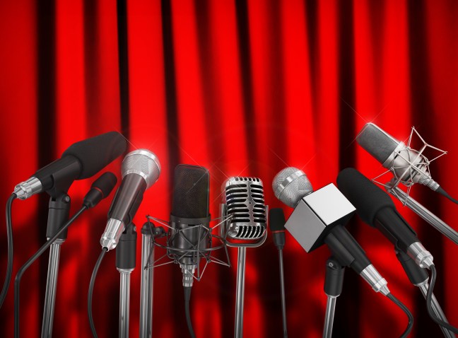 Various microphones aligned at press conference.