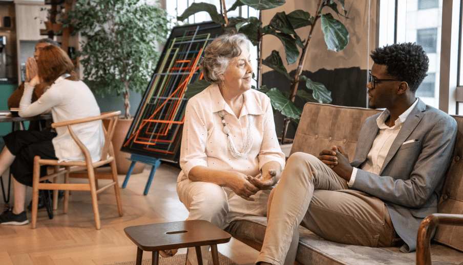 Two people talking on a couch in a modern office
