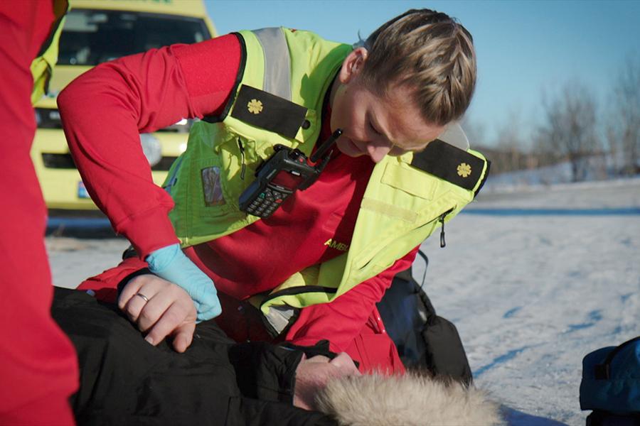 Ambulansearbeider som jobber med pasient