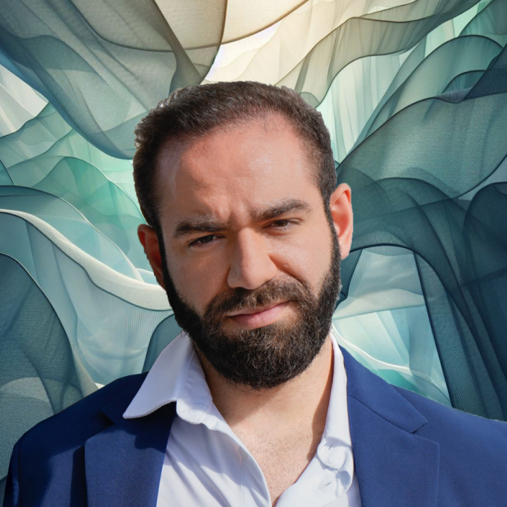 A man with a beard in front of a blue background.