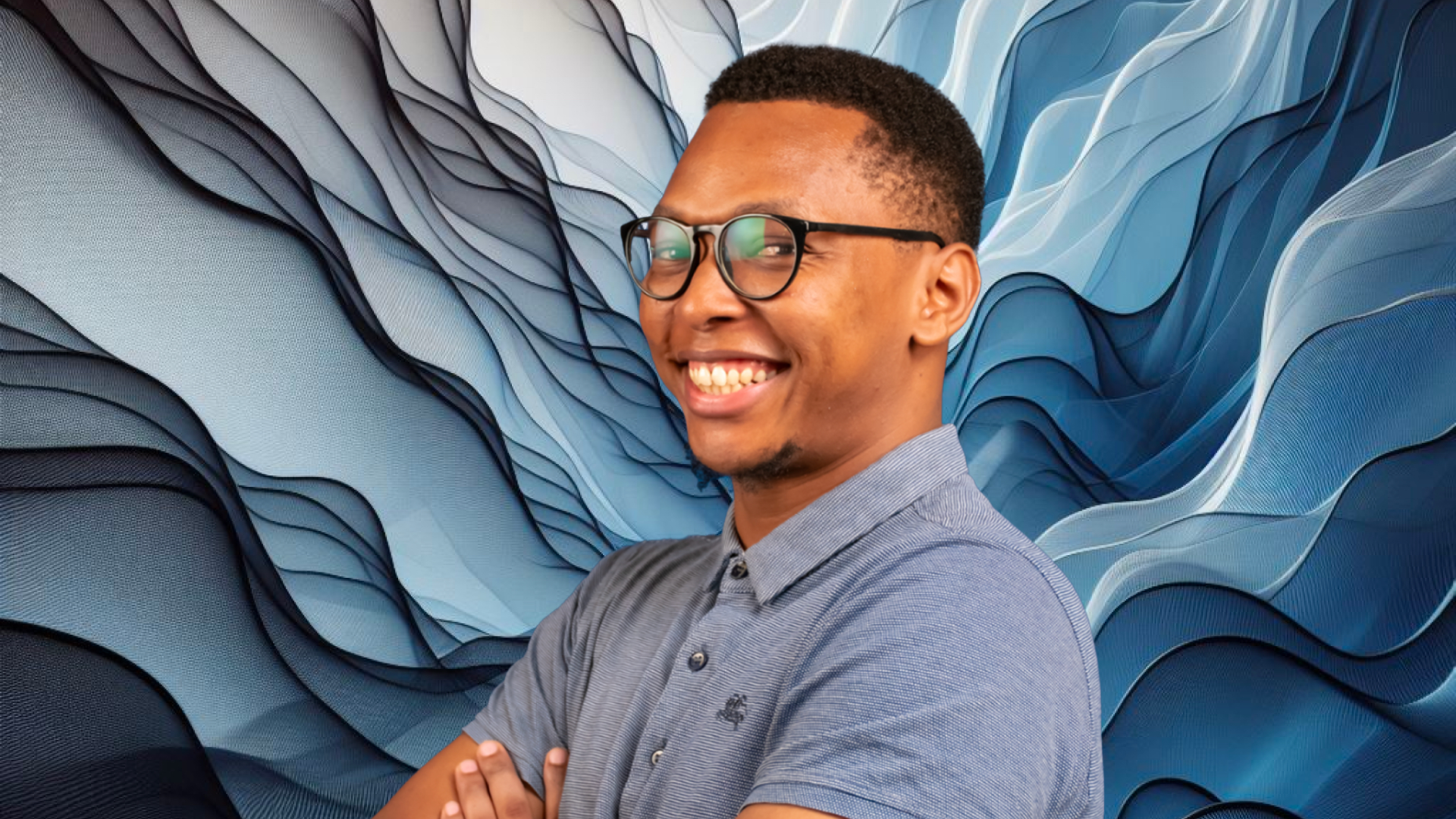 A man in glasses is smiling in front of a blue background.