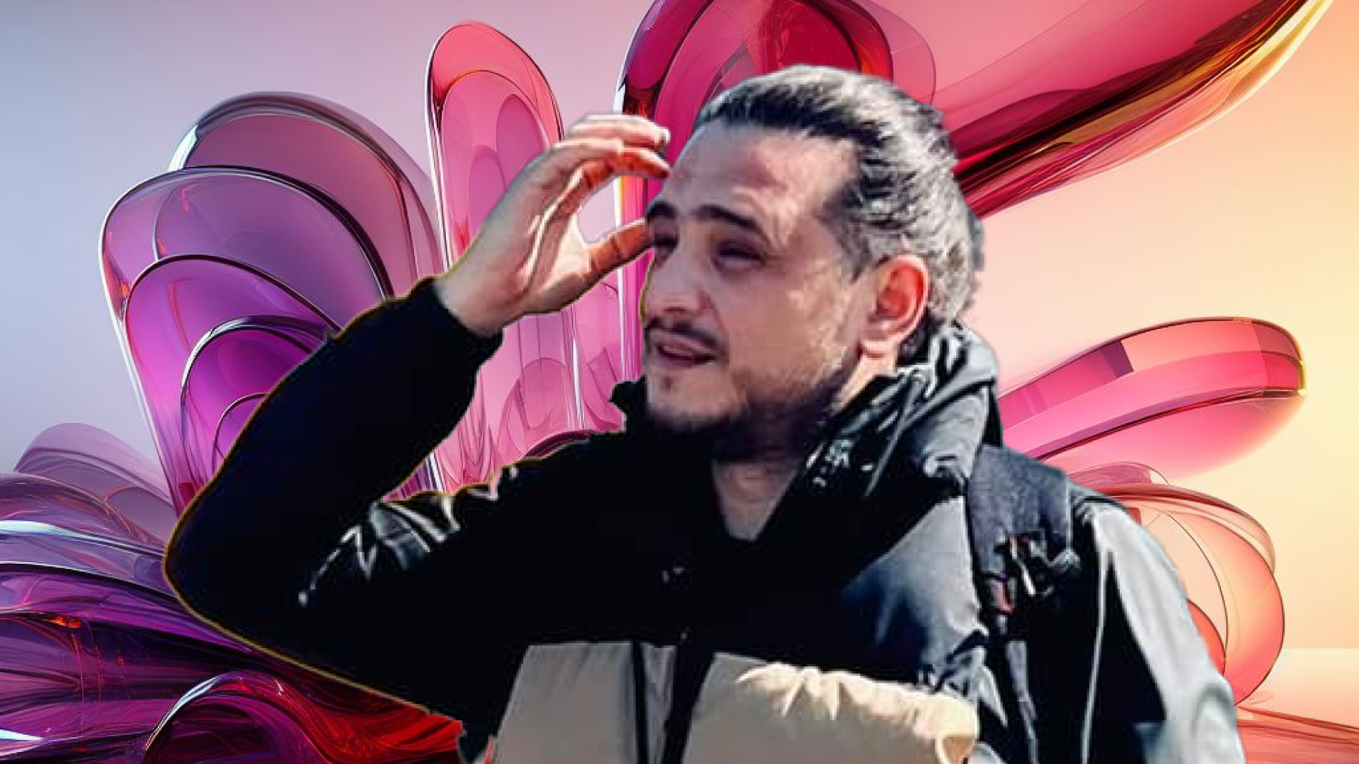 A man in a black jacket appears pensive against a vibrant, abstract background featuring oversized, glossy pink shapes.