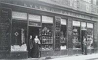 La boutique du 14-16 Basse-Grand-Rue (actuelle rue de la Marne) à Nantes, vers 1905. À gauche, Auguste Évellin.