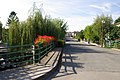 English: Canal and flatboats visible left down under the bridge, village of Le Mazeau.