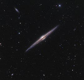 المجرَّة الحلزونيَّة العملاقة NGC 4565 التي تبعد عن الأرض مسافة تتراوح بين 30 و50 مليون سنة ضوئيَّة، وهي مثال بارز لِمجرَّةٍ حلزونيَّةٍ من طرفها