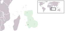 A map with four little green coloured islands in the middle surrounded by a light green area. On the upper right is a small world map using mercator projection. Mentioned islands are in the sea near the lower right side of Africa.