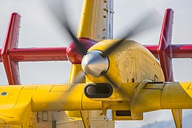 Détail d'un avion jaune avec empennage rouge vu en vol.