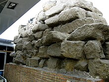 Photographie en couleurs d'un mur composé d'un empilement de gros blocs.