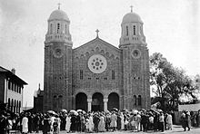 Photographie noir et blanc d'une église avec deux clochers à droite et à gauche du bâtiment.