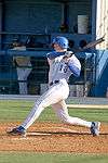 A batter follows through after swinging at a pitched ball