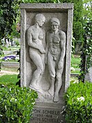 Photo couleur d'une sculpture de pierre rectangulaire avec un homme et une femme en haut-relief