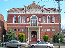 A modern photograph of the Chong Wang Benevolent Association building, a two story brick building incorporating both western and Chinese architectural motifs