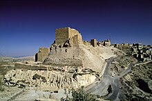 A castle built of stones on a cliff near a settlement