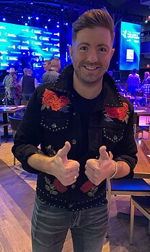 Billy Gilman, giving a thumbs-up to the camera while in a bar