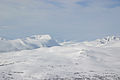 Trollheimen om vinteren sett frå aust. Dalen som skjer i landskapet er Gjevilvassdalen og fjellet som er gryteforma til venstre i biletet heiter Okla. Foto av Hogne.